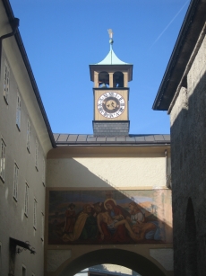 A building over the street with a tower and painting on it