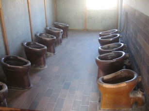 Two rows of toilets in the barracks at Dachau